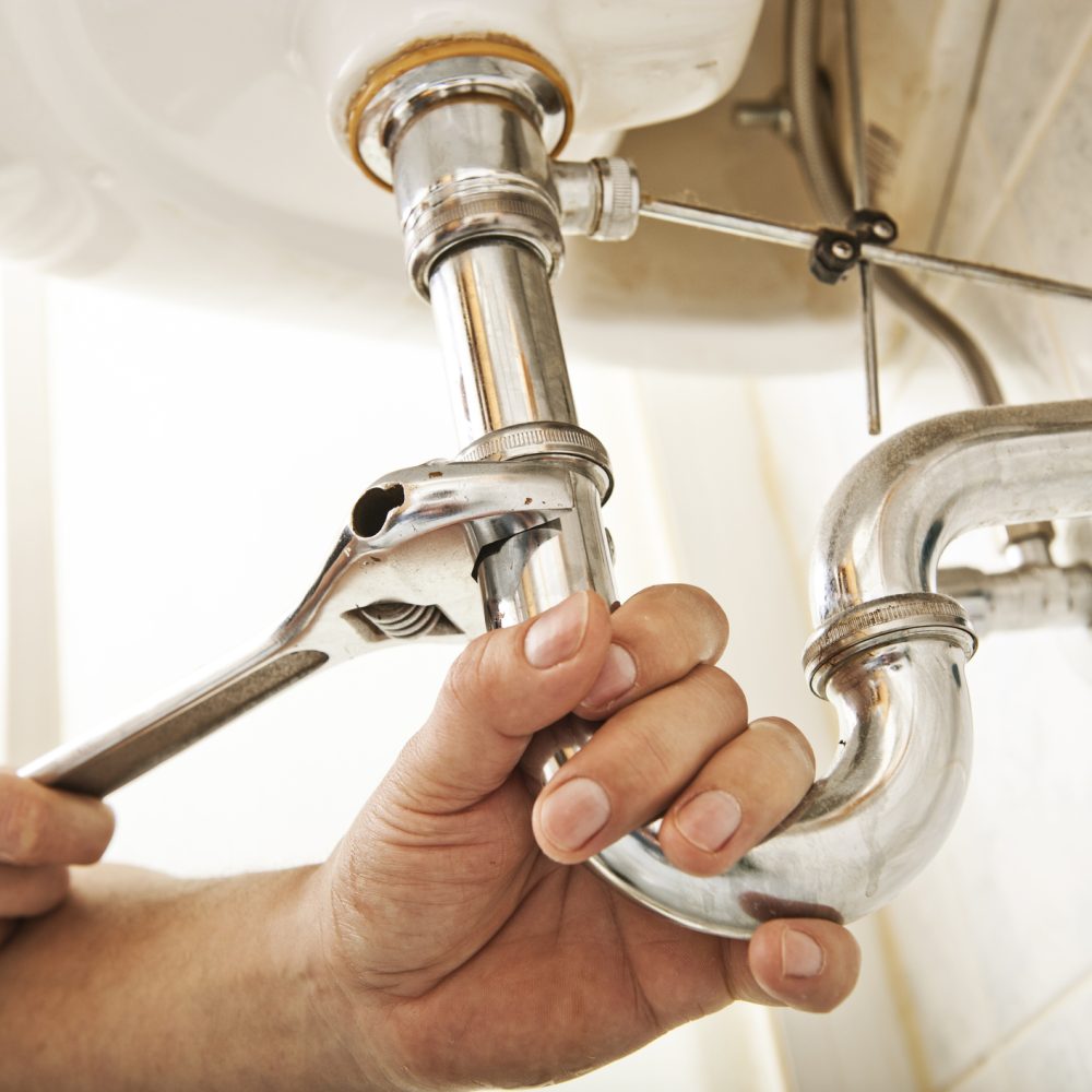 Plumber using a wrench.